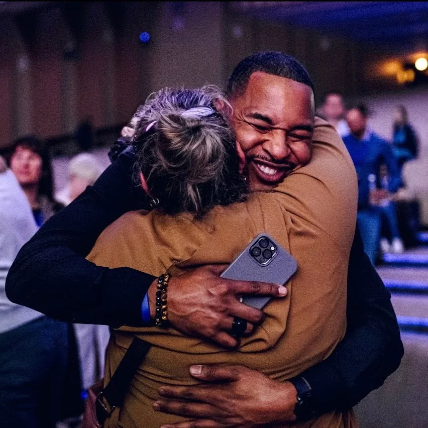 Rob Cook sharing a hug with an event attendee